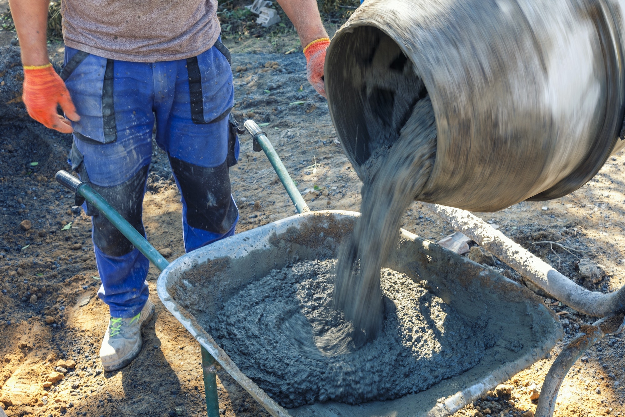 Builder pouring cement from a cement mixer